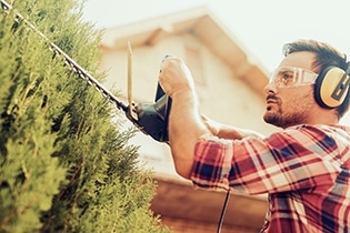 Man wearing hearing protection while trimming trees