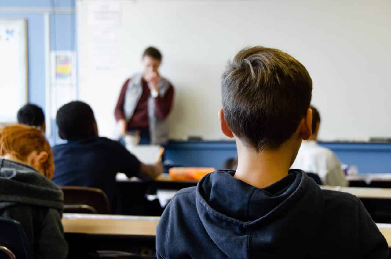 Child listening to a teacher in a class.