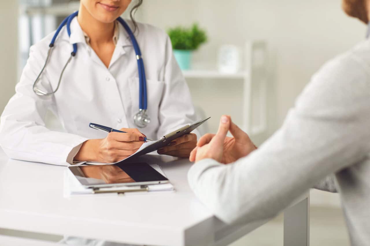 Doctor speaking with a patient in doctor's office setting.