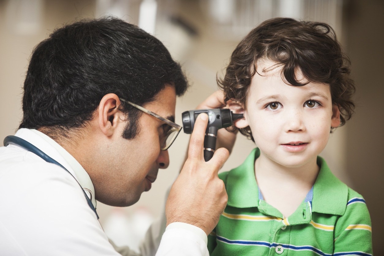 Toddler-aged boy getting an ear exam as part of a hearing test.