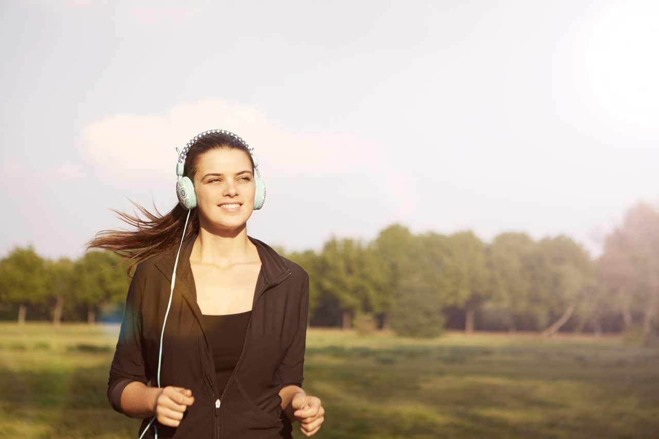 Woman with headphones jogging outside.