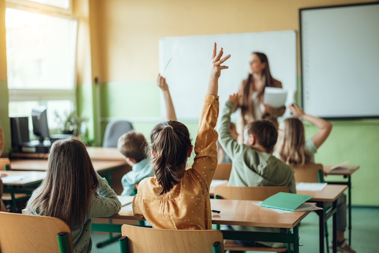 Kids in class raising their hands