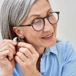 Woman putting on a hearing aid
