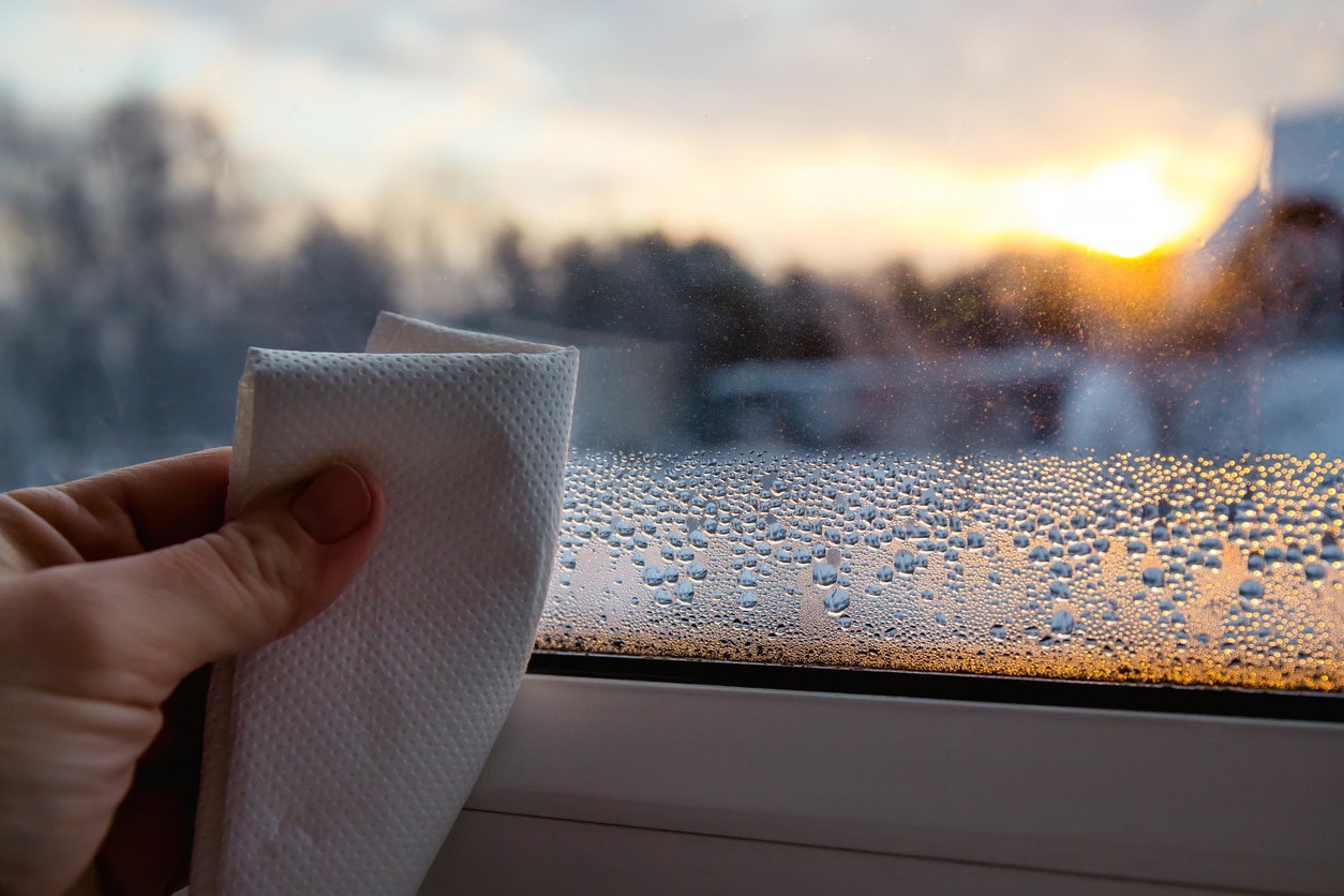 Wiping humidity off a windowsill.