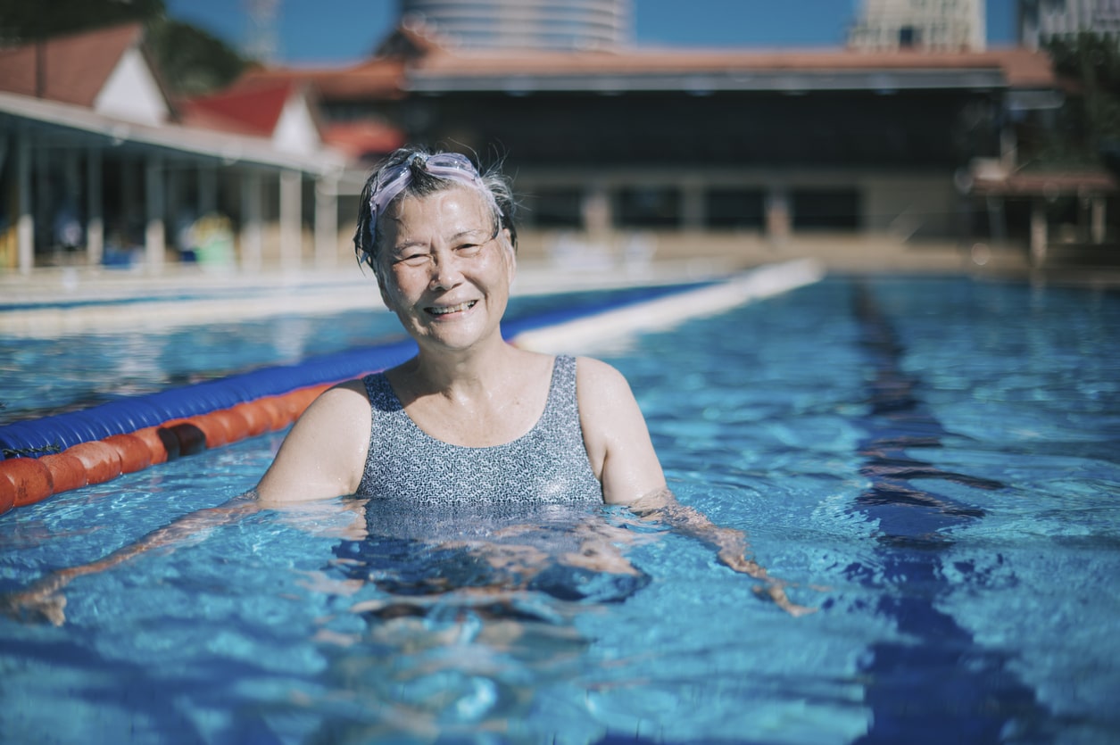 Senior woman smiling in a swimming lane.