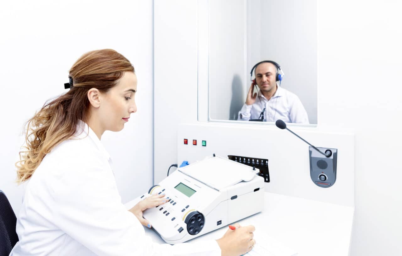 Audiologist administering a hearing test.