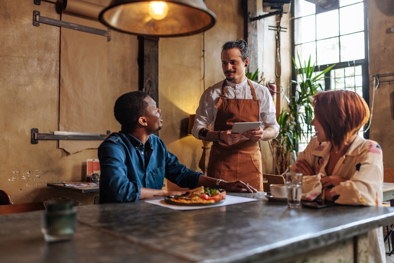 Couple ordering food from a restaurant server.