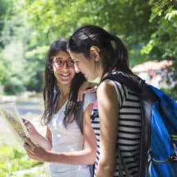 Young teen with a hearing aid walking with her friend