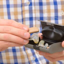 Closeup of a man holding his new hearing aids