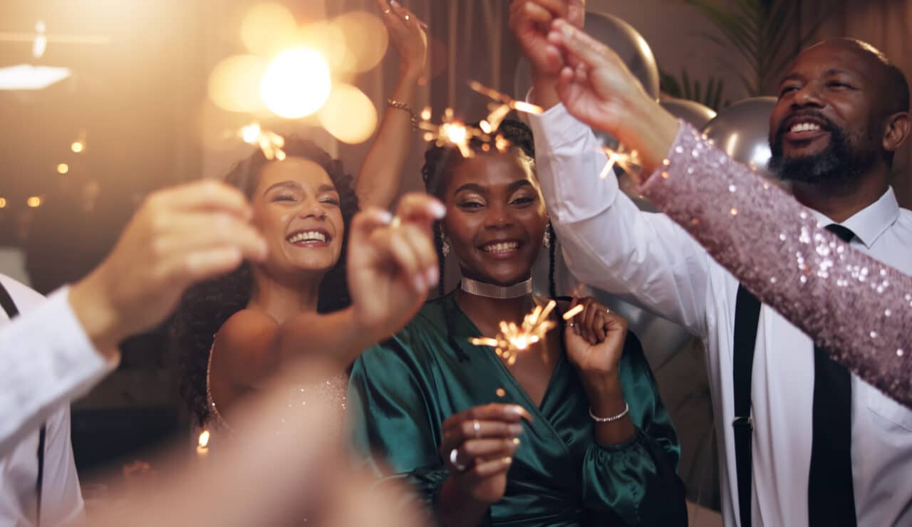 Group of friends holding sparklers on new year's eve.