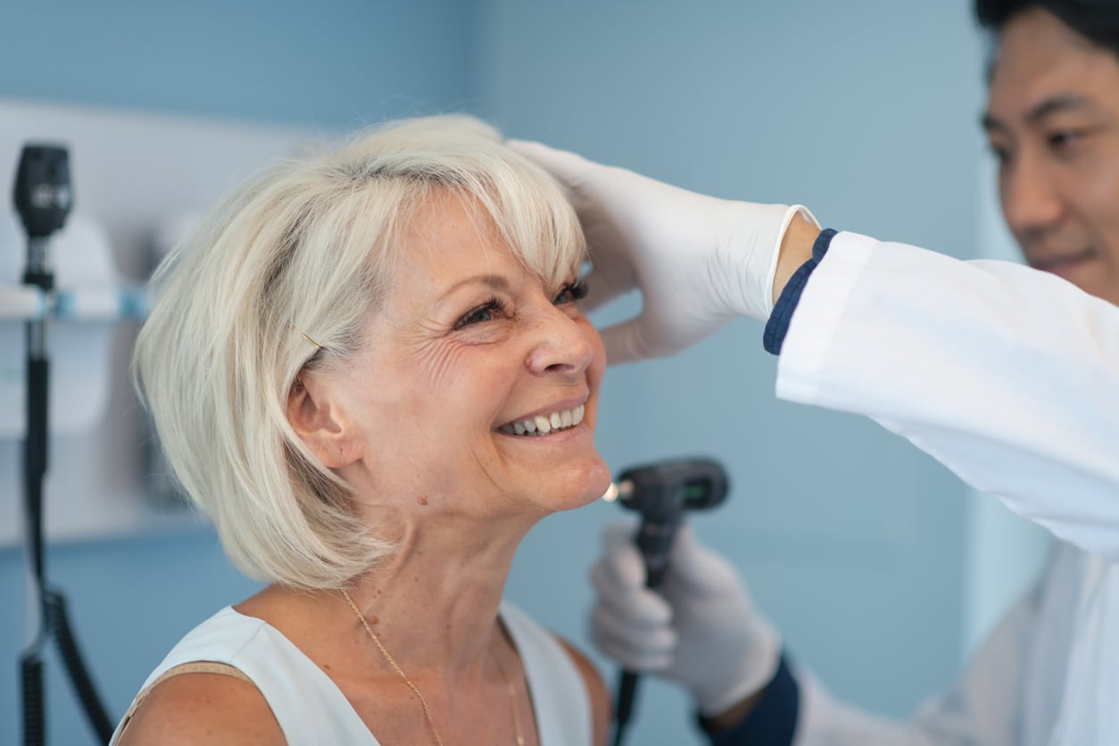 Smiling woman in an ear exam.