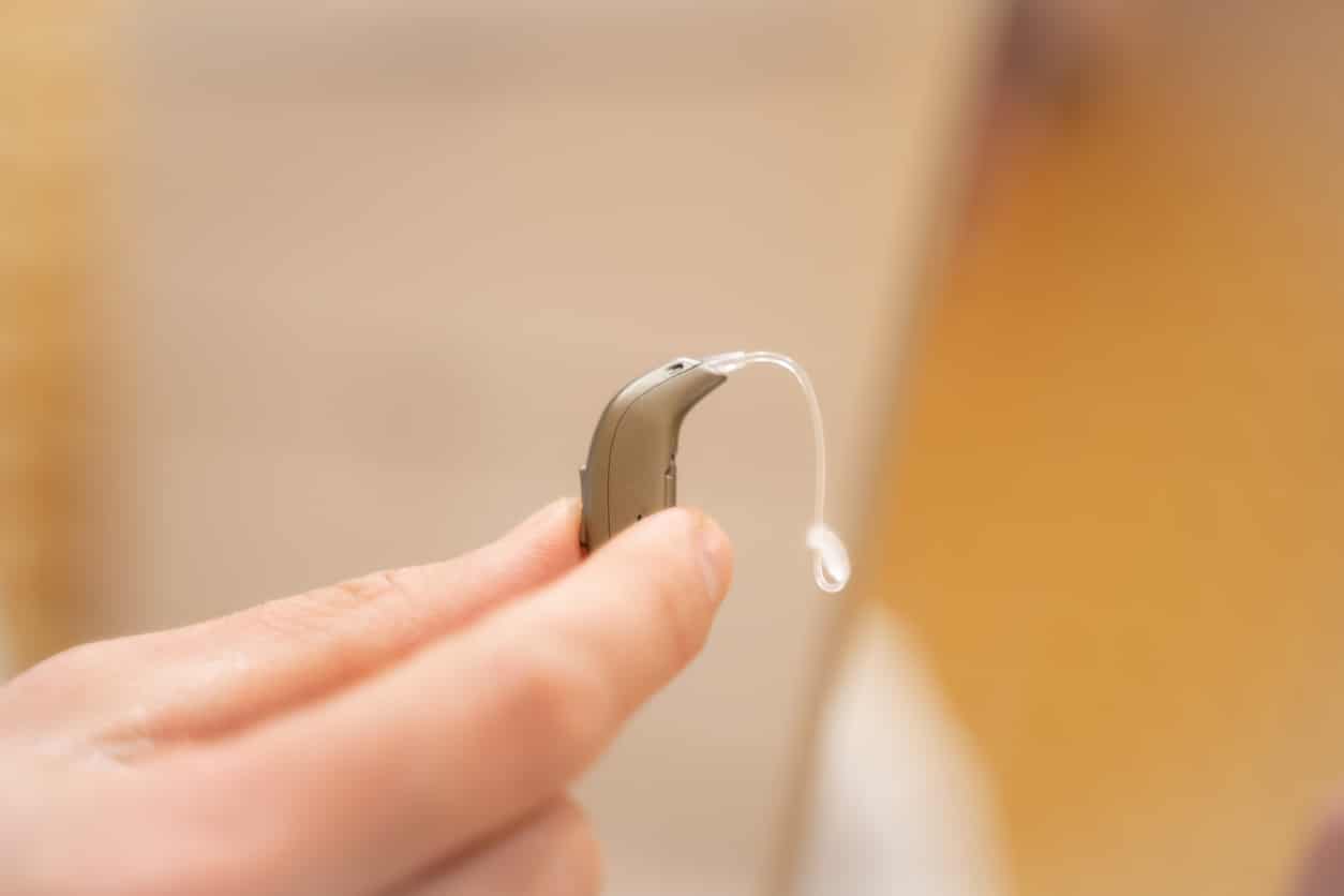 Hand holding an advanced hearing aid.